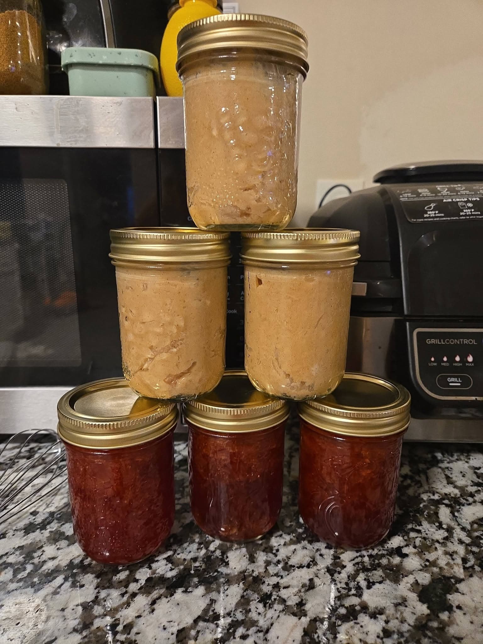 Homemade goods in glass jars stacked on a kitchen counter